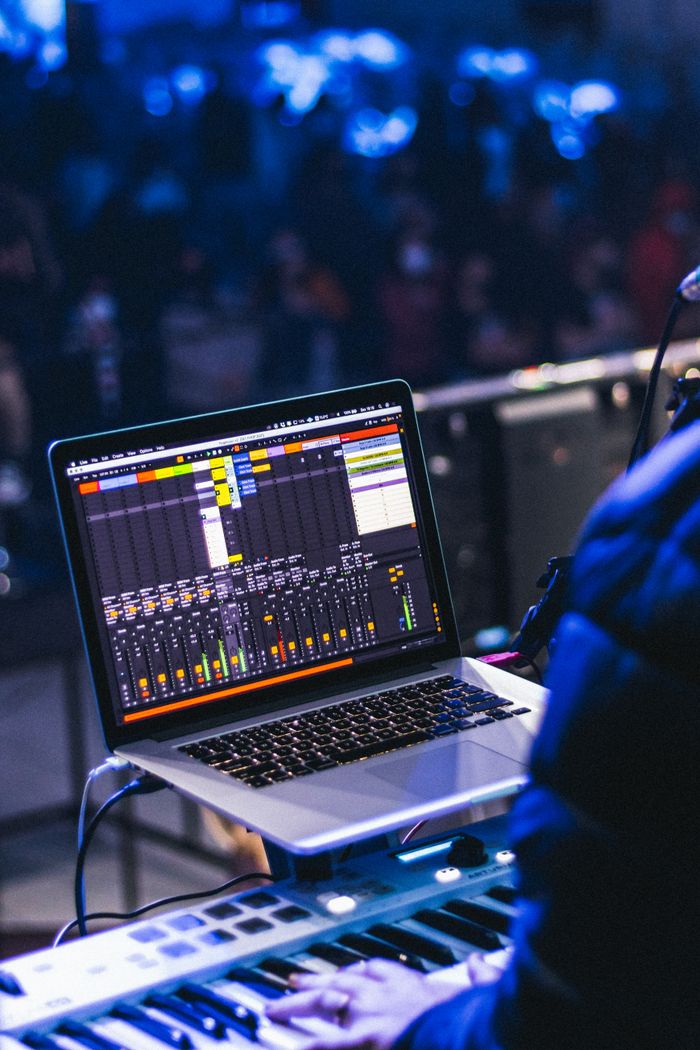 About Musician using laptop for mixing during live performance in concert setting